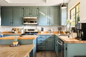 eine Küche mit grünen Schränken und Holzoberflächen in der Unterkunft Lumiere Cabin in Blue Jay + 16 Fotos