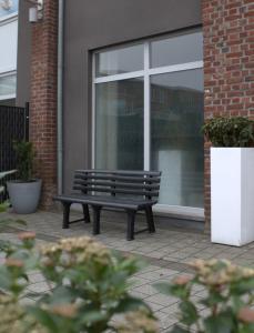 un banc assis devant une fenêtre dans l'établissement Casa Verde, à Maasmechelen