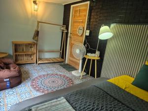 a room with a bed and a fan and a door at Baan Koody Hostel in Ko Kut