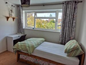 ein kleines Schlafzimmer mit einem Bett und einem Fenster in der Unterkunft Ahmadiyya in 