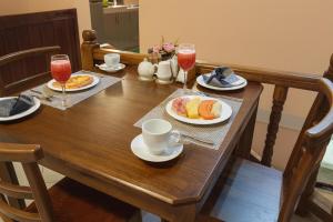 a wooden table with plates of food and glasses of wine at PearlDrop Hills Kandy in Kandy