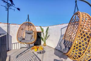 zwei Hängesessel auf einem Balkon mit einer Obstschale in der Unterkunft VILLA T to15 min from Puy du Fou Billiar, Movies, BBQ,Pool in Totanés