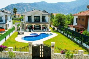 a house with a swimming pool in a yard at Villa-Sleeps 9-Parking-Pool-Bbq-Hot tub-Pets in Dalyan
