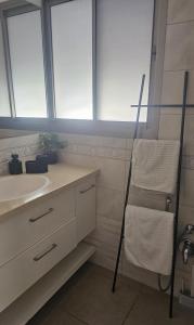 a bathroom with a sink and a towel rack at הבית בשביל הזהב in Caesarea