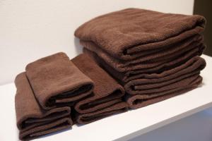 ein Haufen brauner Handtücher auf einem Regal in der Unterkunft Sen Yokohama 2K house near Bandobashi Sta 横浜阪東橋 in Yokohama