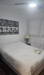 a bedroom with a bed and a painting on the wall at הבית בשביל הזהב in Caesarea