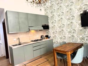 una cucina con mobili bianchi e un tavolo di legno di Amedeo Apartment a Roma