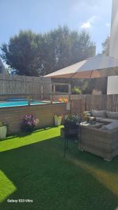 a patio with an umbrella next to a pool at הבית בשביל הזהב in Caesarea