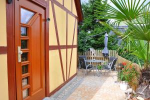 eine offene Tür zu einer Terrasse mit einem Tisch und einem Sonnenschirm in der Unterkunft Ferienhaus Neubert in Wolkenstein