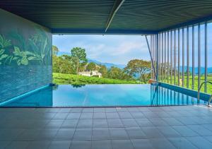 a swimming pool in a house with a view at The Saray Munnar by VOYE HOMES in Anachal