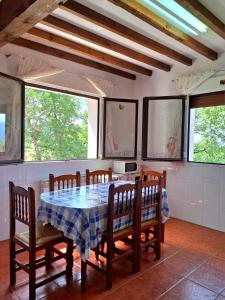 a dining room with a table and chairs and windows at Casa Cordovilla in Sequeros