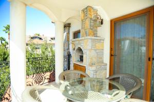 a patio with a glass table and chairs on a balcony at Hot tub-Fireplace-Pets-Sleeps 11-Bbq-Pool-Parking in Dalyan +39 photos