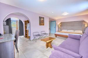 uma sala de estar com uma cama e um sofá roxo em Domaine du lac bleu em Saint-Laurent du Maroni