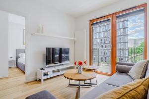 Una sala de estar con un sofá y un televisor en ShortStayPoland Zdziechowskiego, en Varsovia