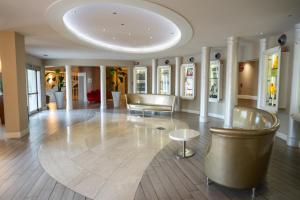 Rodengo Saiano莫格那酒店的大堂配有沙发、椅子和桌子