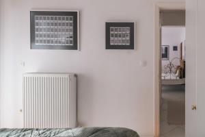 une chambre avec un radiateur et deux photos sur le mur dans l'établissement TripoliStay, à Tripoli 2 autres photos