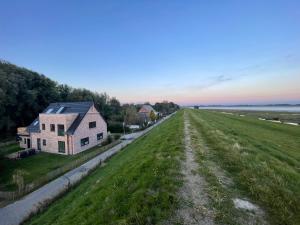 eine Luftansicht eines Hauses und eines Feldes in der Unterkunft Deichkoje12 Deck 1 EG direkt am Eiderdeich nur 7 km bis zur Nordsee und 20 Min bis Sankt Peter Ording in Tönning