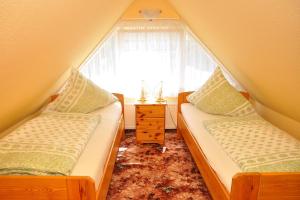 2 Betten in einem Dachzimmer mit Fenster in der Unterkunft Ferienhaus Neubert in Wolkenstein