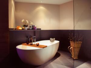 a bathroom with a bath tub with a table on it at Hotel Eden No. 7 in Saas-Fee +34 photos