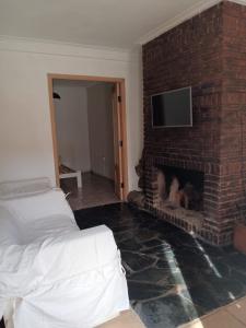 a living room with a brick fireplace with a tv at Paz in Tandil
