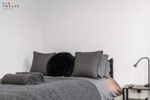 a white bedroom with a bed with a pillow on it at Bright & Modern Room in Brixton - Shared Bathroom in London