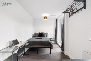 a bedroom with a bed and a desk with a laptop at Bright & Modern Room in Brixton - Shared Bathroom in London