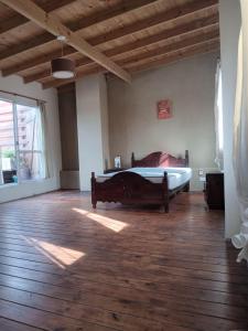 a bedroom with a bed and a wooden floor at Paz in Tandil