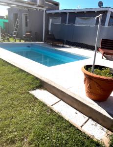 een zwembad met een plantenbak naast een huis bij Cab19,Anisacate in Alta Gracia