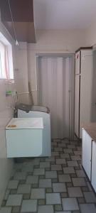 a bathroom with a toilet and a tiled floor at Quartos em Maceio à 100m da praia in Maceió