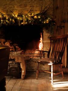a room with a fireplace with a bench and christmas lights at The Stump in Cirencester