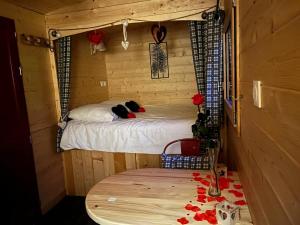 Zimmer mit einem Bett und einem Tisch in einem Zimmer in der Unterkunft Roulotte - Etat Nature in Magnières