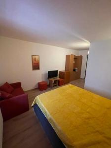 - une chambre avec un grand lit jaune et un canapé dans l'établissement 4 Hordó - Panzió és Étterem, à Komárom