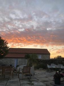 um conjunto de cadeiras e mesas em um pátio ao pôr do sol em Casa Lela Dumbria em Dumbría