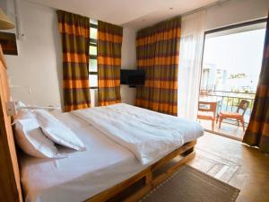 Ένα ή περισσότερα κρεβάτια σε δωμάτιο στο Villa Alizée - Boutique Hôtel Expérience - Idéal Couples & Pros - Piscine - Restaurant - Rooftop bar - Parking privé - 10min Port-Louis - Ambiance Tropical chic & authentique