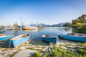 three boats sitting on the shore of a body of water at Alpenloft mit Garten & BBQ am Chiemsee by Dollop Living in Bernau am Chiemsee