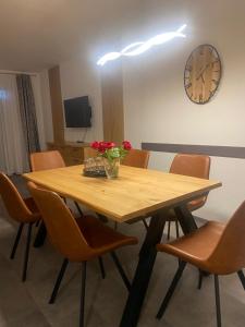 a wooden table with chairs and a clock on the wall at Ferienwohnung-fein in Bad Sachsa