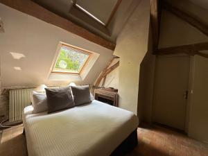 a bedroom with a bed in a room with a window at Ferme du Haute du Château in Villecerf