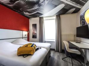 a hotel room with two beds and a desk at Ibis Styles Strasbourg Centre Gare in Strasbourg +53 photos