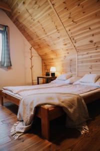 un letto grande in una stanza con soffitto in legno di Dom na Padole a Tylmanowa