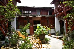 a courtyard of a house with chairs and plants at Shaoxing Laotaimen Luxun Native Place Youth Hostel in Shaoxing