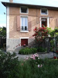 a house with a balcony and flowers in front of it at Beautiful apartment in Provençal residence with garden and WiFi in Digne-les-Bains