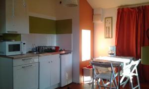 a kitchen with a microwave and a table and chairs at Beautiful apartment in Provençal residence with garden and WiFi in Digne-les-Bains