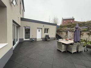 Un patio con mesa y sillas y un edificio. en Melo, en Plombières