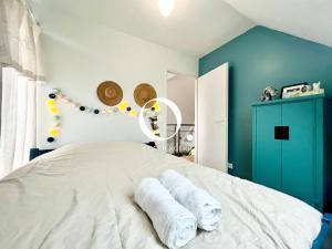 a bedroom with a white bed with towels on it at COC - Le Gulistan in Wissant