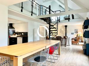 a kitchen and living room with a wooden table and chairs at COC - Le Gulistan in Wissant