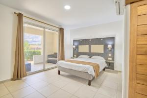 um quarto com uma cama grande e uma varanda em Domaine du lac bleu em Saint-Laurent du Maroni mais 73 fotografias