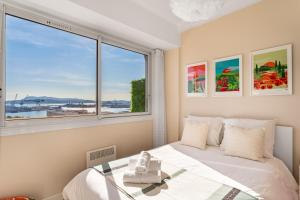 a bedroom with a bed and a large window at Magnifique appartement climatisé vue mer in Toulon