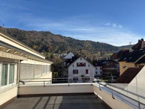 a balcony with a view of a town and mountains at Hotel MaMa in Bregenz