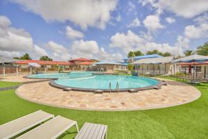 uma grande piscina com duas espreguiçadeiras em um quintal em Domaine du lac bleu em Saint-Laurent du Maroni