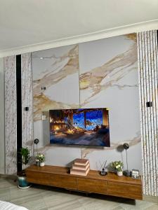 a living room with a tv on a wall at Suite Nothings in Kampala
